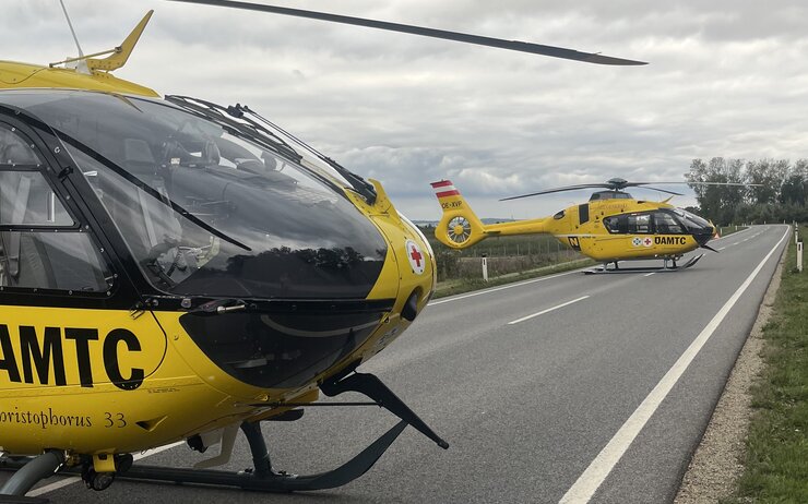 Christophorus 33 und Christophorus 2.jpeg Zwei gelbe Notarzthubschrauber, die auf einer Straße gelandet sind