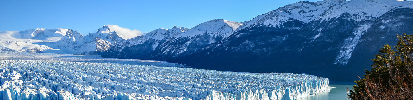 Der Perito Moreno Gletscher in Argentinien, mit seinen schimmernden Eisflächen und dramatischen Eisabbrüchen, ist ein beeindruckendes Schauspiel vor der majestätischen Kulisse der umliegenden Berge.