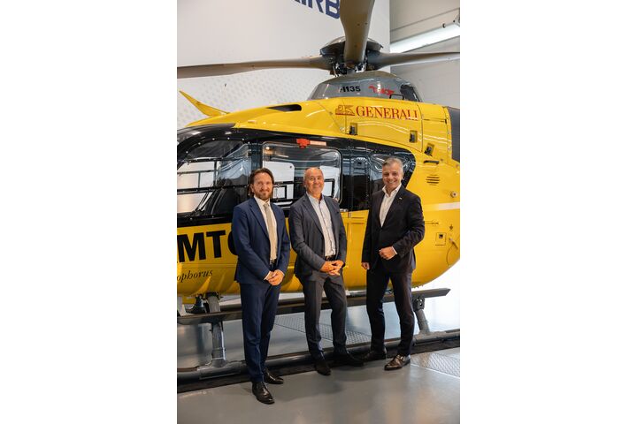 Personen stehen vor einem Hubschrauber