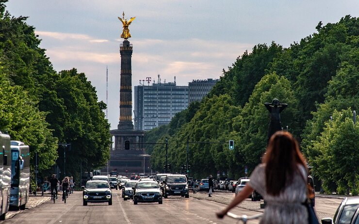 Deutschland Verkehrsregeln Straße in Berlin mit Autos und Radfahrerin