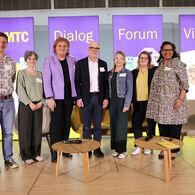 Auf dem Foto sind stehende Menschen auf einer Bühne zu sehen. Im Hintergrund sind Aufsteller mit dem Schriftzug "ÖAMTC Dialog Forum Vielfalt" zu sehen.