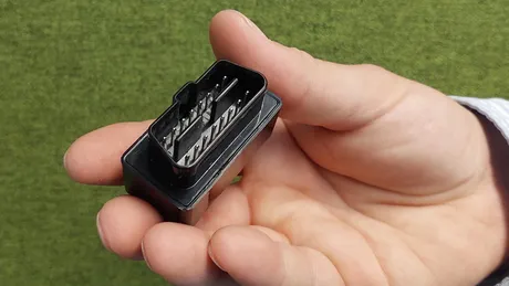 Eine Hand in Großaufnahme zeigt einen Dongle.