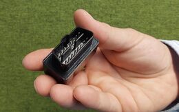 Eine Hand in Großaufnahme zeigt einen Dongle.