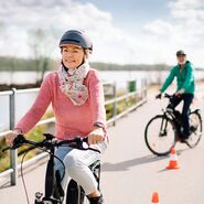 Zwei ältere Teilnehmerin:nnen mit Fahrradhelm auf E-Bikes während einer Ausfahrt beim ÖAMTC E-Bike-Kurs.