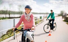 Zwei ältere Teilnehmerin:nnen mit Fahrradhelm auf E-Bikes während einer Ausfahrt beim ÖAMTC E-Bike-Kurs.