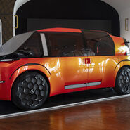 Der Citroen Elo. Er ist Orange, seitlich fotografiert. Er ist sehr futuristisch.