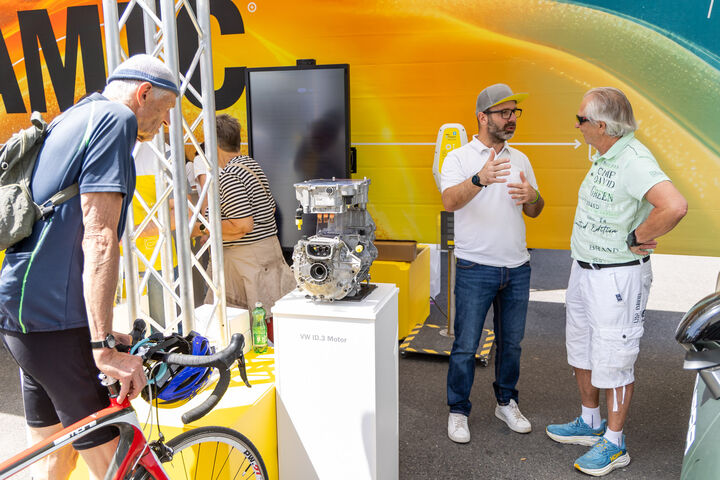 ÖAMTC Experte berät am ÖAMTC Messestand während ein Besucher einen ausgestellten Elektromotor begutachet