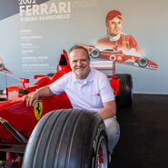 Rubens Barrichello kniet vor einem Formel-1-Ferrari von 2002.