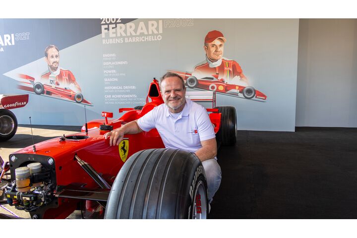 Rubens Barrichello kniet vor einem Formel-1-Ferrari von 2002.