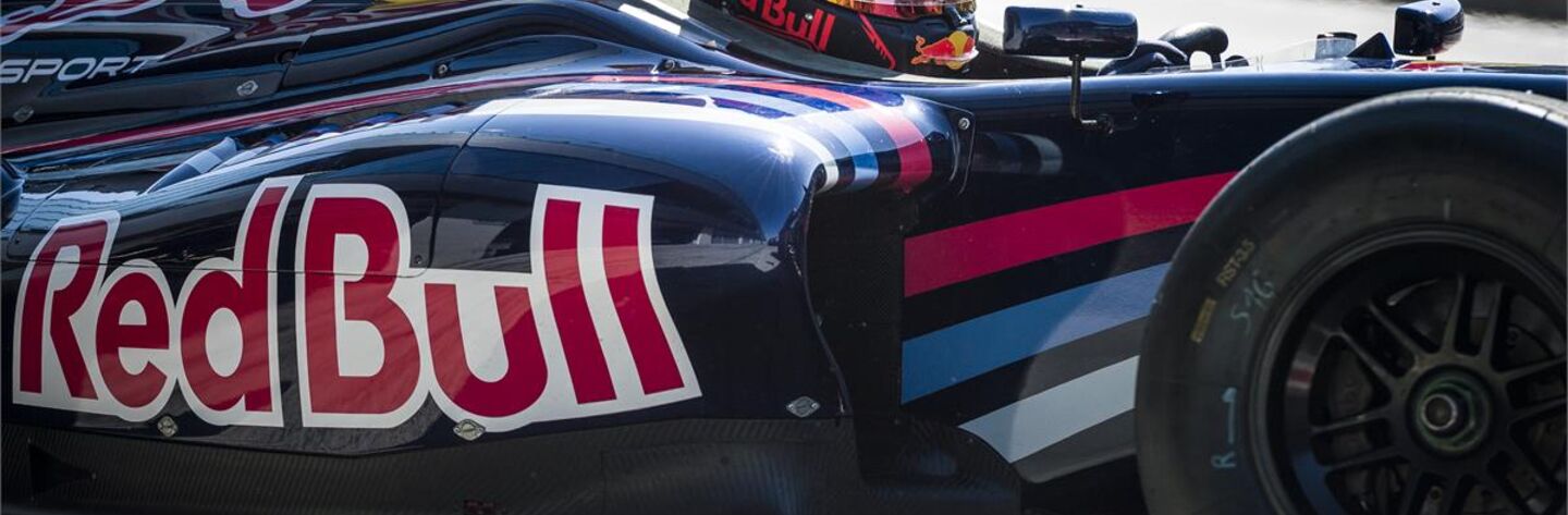 Ausschnitt eines Formel 1 Fahrzeugs mit Fahrer der einen Helm trägt.