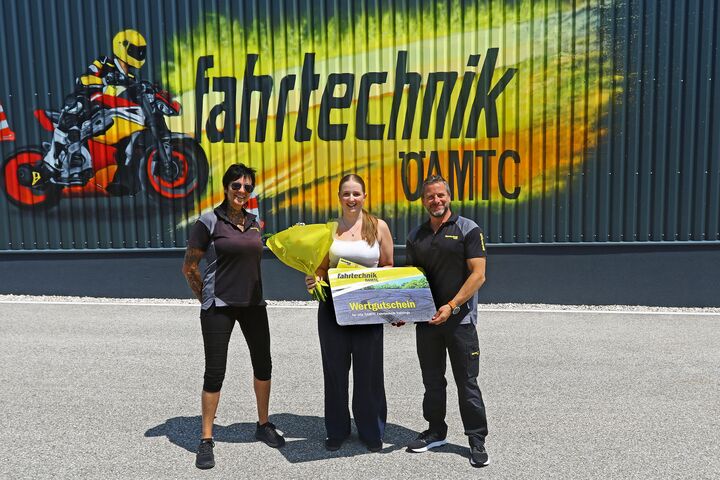 Die 150.000ste Teilnehmerin zusammen mit Zentrumsleiter Andreas Rouschal und Patricia Altmann vor einer Fahrtechnik-Graffitiwand