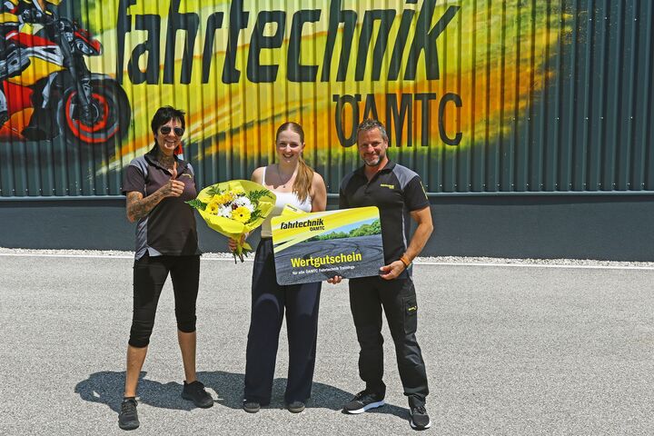 Die 150.000ste Teilnehmerin zusammen mit Zentrumsleiter Andreas Rouschal und Patricia Altmann vor einer Fahrtechnik-Graffitiwand