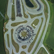 Luftaufnahme des Fahrtechnik Zentrums Lang-Lebring in der Steiermark. Man sieht Gebäude, einen Parkplatz sowie eine Strecke mit verschiedenen kurvigen Streckenabschnitten für Fahrsicherheitstrainings