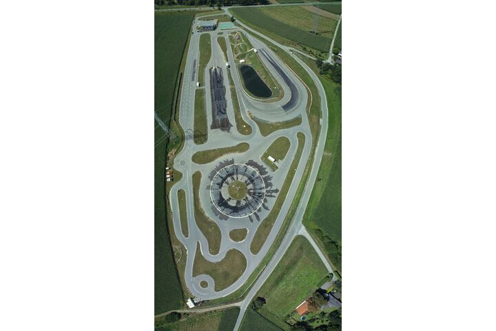 Luftaufnahme des Fahrtechnik Zentrums Lang-Lebring in der Steiermark. Man sieht Gebäude, einen Parkplatz sowie eine Strecke mit verschiedenen kurvigen Streckenabschnitten für Fahrsicherheitstrainings