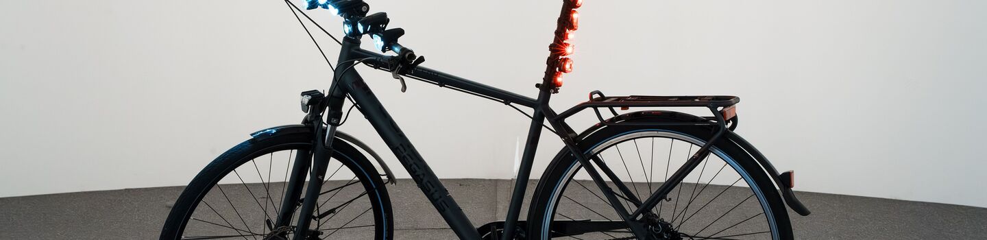 Fahrrad in Testhalle mit diversen Front- und Hecklichtern.