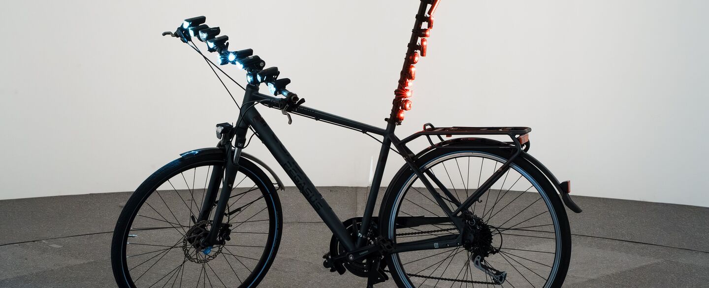 Fahrradlichttest 2025 Fahrrad in Testhalle mit diversen Front- und Hecklichtern.