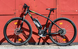 E-Bike der Marke KTM steht vor rotem Tor.