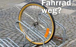 Einzelnes Fahrradrad steckt in einem Fahrradständer. Darüber steht in weißer Schrift - Fahrrad weg?