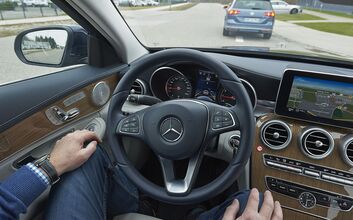 Fahrspurassistenzsysteme Cockpit eines fahrenden Autos - der Lenker hat die Hände nicht am Lenkrad ,sondern auf seinen Knien.
