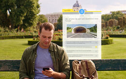 Junger Mann sitzt bei schönem Wetter auf einer Parkbank und blickt konzentriert auf sein Smartphone in der Hand. Im Hintergrund sieht man eine Frage eingeblendet zu einer Tunnel-Durchfahrt der ÖAMTC Führerschein-Test App.