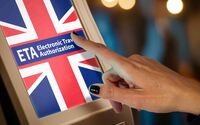 Ein Bildschirm, der eine britische Flagge mit dem Schrifzug ETA Electronic Travel Authorization zeigt, und eine Hand, die den Bildschirm berührt