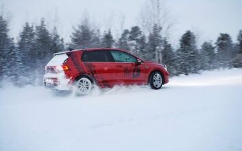 Ein rotes Auto auf Schneefahrbahn.