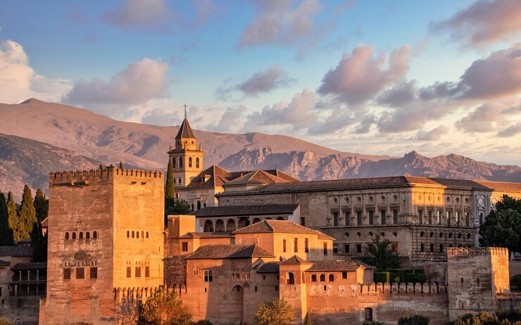 Das Foto zeigt die Alhambra in der Abendsonne vor den Gipfeln der Sierra Nevada.