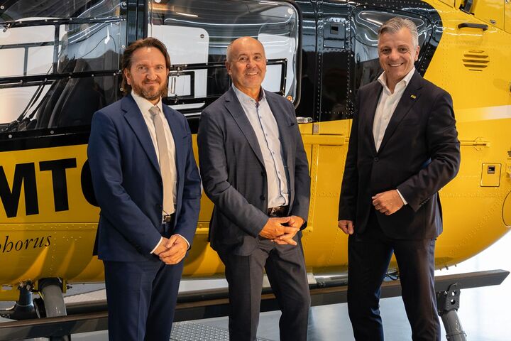 Drei Personen vor einem ÖAMTC Hubschrauber
