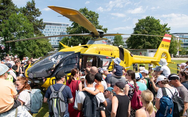 Besuchende stehen um den Notarzthubschrauber herum, nachdem er im Zuge der Veranstaltung gelandet ist.