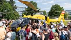 Besuchende stehen um den Notarzthubschrauber herum, nachdem er im Zuge der Veranstaltung gelandet ist.