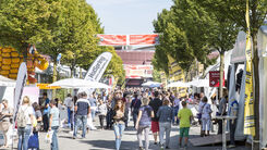 Viele Messebesucherinnen und Besucher im Freigelände einer Messe unterwegs.
