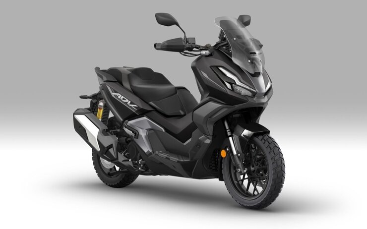Honda ADV350.jpg Das Bild zeigt ein stehendes Motorrad vor einem grauen Hintergrund.