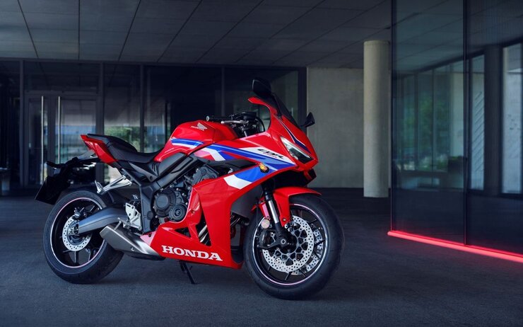 Honda CBR 650R.jpg Das Foto zeigt ein Rot-Blaues Motorrad, das vor einem Gebäude steht.