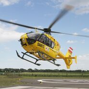 Ein gelber Notarzthubschrauber hebt von seinem Landeplatz aus ab