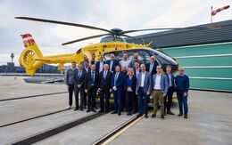 Die Teilnehmer:innen der Generalversammlung der Joint European Drone Associations stehen am Dachlandeplatz von Christophorus 9 vor einem Hubschrauber.