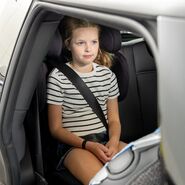 Eines der Testkinder posiert für ein Foto, während es in einem Kindersitz sitzt.