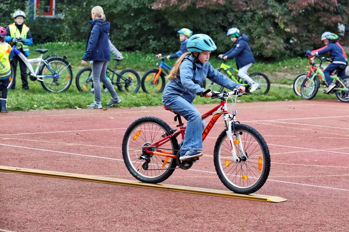 Ein Kind balanciert sein Fahrrad auf einer schmalen Fahrspur