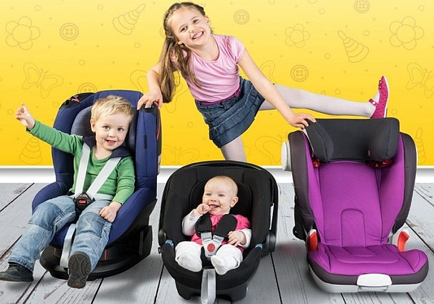 Drei Kinder, die spielerisch die Funktionalität und den Komfort von Kindersitzen testen.