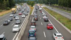 Luftaufnahme einer Autobahn. In beide Fahrtrichtungen stehen die Fahrzeuge hintereinander im Stau. 