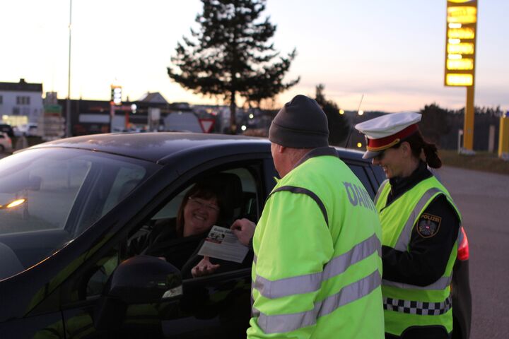 Ein ÖAMTC-Techniker klärt gemeinsam mit einer Polizistin eine angehaltene Fahrerin über die Aktion "Flugzettel statt Strafzettel" auf