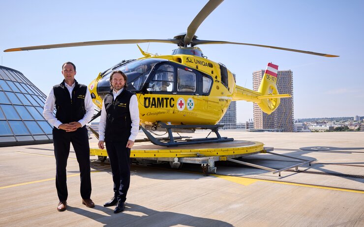 2 Männer vor einem ÖAMTC Hubschrauber