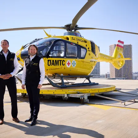 2 Männer vor einem ÖAMTC Hubschrauber