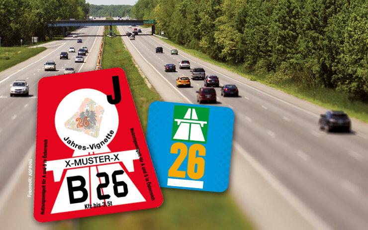 Eine Autobahn mit zwei Vignetten als Sticker im Vordergrund.