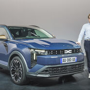 Einee Person im Hemd steht neben einem blauen Dacia Striker.
