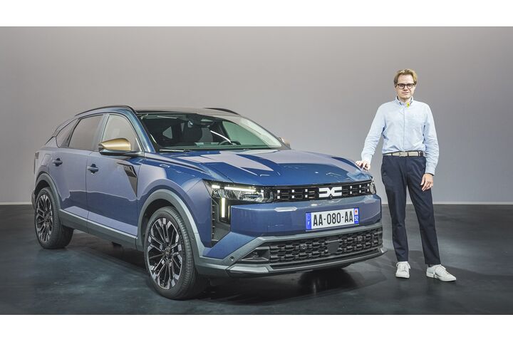 Einee Person im Hemd steht neben einem blauen Dacia Striker.