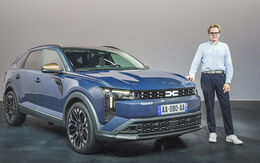 Einee Person im Hemd steht neben einem blauen Dacia Striker.