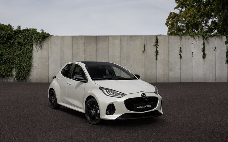 Mazda 2 Hybrid.jpg Das Foto zeigt ein Fahrzeug vor einer Wand.