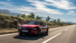 Das Foto zeigt ein fahrendes rotes Auto.