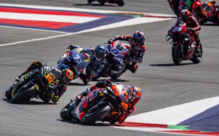 MotoGP AUT Race Action Michael Jurtin Red Bull Ring.jpg Eine Gruppe von Rennfahrern auf Motorrädern fährt schnell über die Strecke.