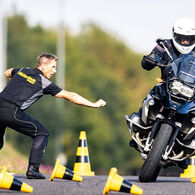 Ein Instrukor der ÖAMTC Fahrtechnik gibt einem Motorradfahrer energisch Anweisungen fürs korrekte Fahren